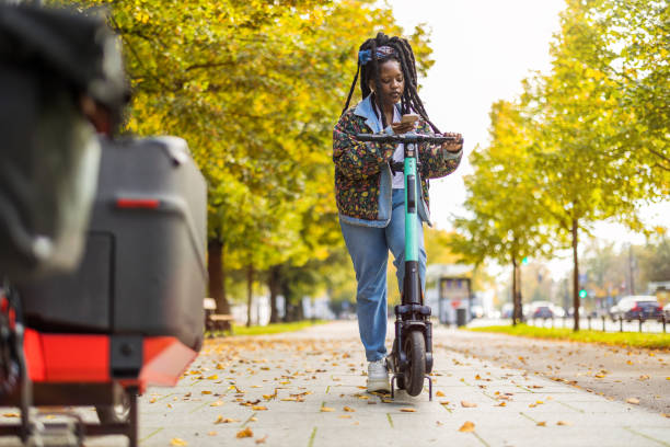 Young woman with electric scooter checking her smartphone