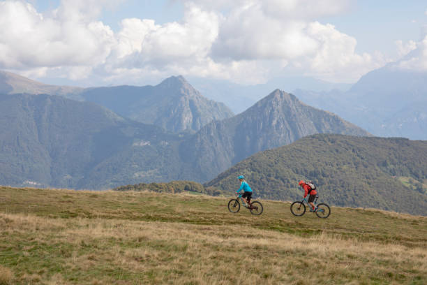 istock Mountain bikers follow trail on grassy mountain ridge 1351829276