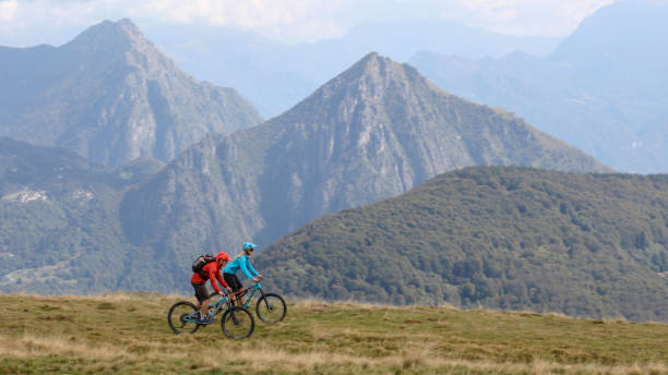 istock Mountain bikers follow trail on grassy mountain ridge 1351829293