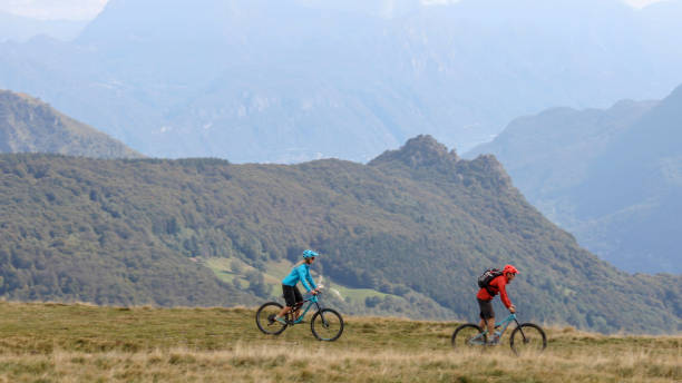 istock Mountain bikers follow trail on grassy mountain ridge 1351829378