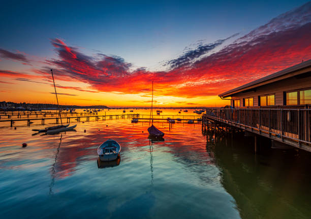 Spectacular sunset over boats at Sandbanks, Poole Harbour, Dorset The view from Sandbanks, Poole Harbour, has often been considered one of the best places in the UK to catch the sunset sandbanks poole harbour stock pictures, royalty-free photos & images