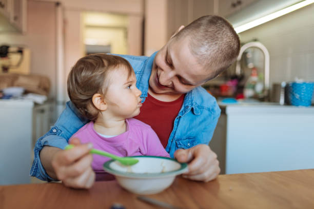 madre guarita dal cancro che fa colazione con la figlia - cancer chemotherapy drug baby family foto e immagini stock