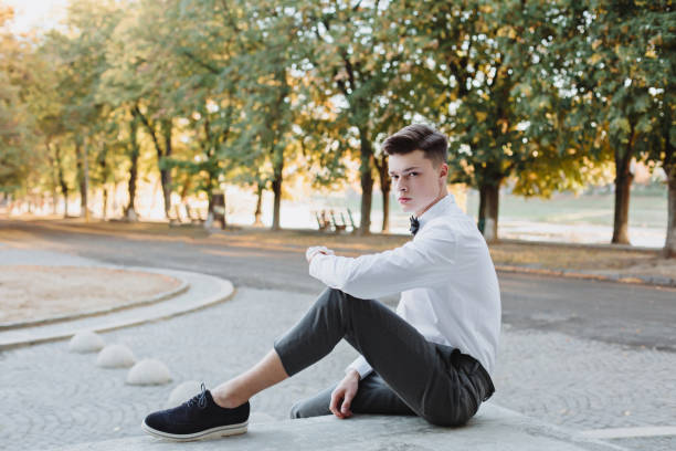 istock A student in a shirt with a sweater and a bow tie looks into the future. 1351829689