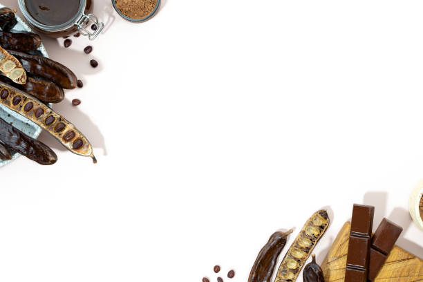 Organic carob pods, powder and carob molasses on a beige background, locust bean healthy food, Ceratonia siliqua harnup. Natural vegan eating. Creative food background. Copy space. Flat lay.Top view vainas de algarroba orgánicas, melaza en polvo y algarroba sobre fondo beige, alimento saludable para algarrobas, ceratonia siliqua harnup. alimentación vegana natural. fondo creativo de comida. espacio de copia. estación plana. vista superior