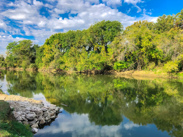 istock River loading ramp with rocks and mirror reflection along Denton Creek – Trinity River near Dallas, Texas, USA 1351834920