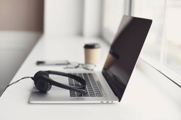 istock Place of work. Laptop computer and headset on a table at home 1351835407
