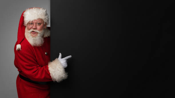 istock Santa Claus pointing black billboard 1351835513