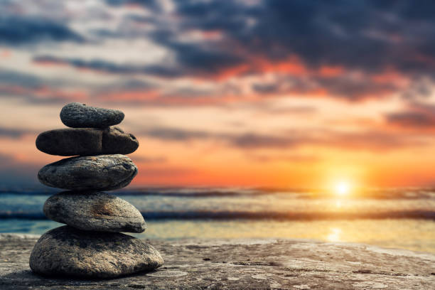 zen pyramid of stones on the background of sunset and sea - tranquilidade imagens e fotografias de stock