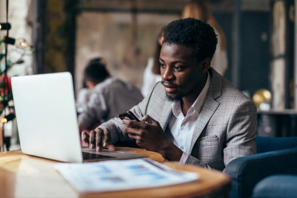 istock Black man at a table in a cafe with a laptop 1351837370