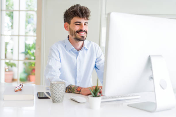 istock Handsome business young man working using computer, smiling confident and concentrated at the office 1351837949