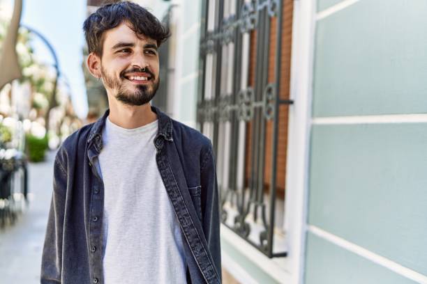 istock Young hispanic man smiling happy standing at the city. 1351837962