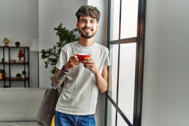 istock Young hispanic man smiling confident drinking coffee at home 1351837987