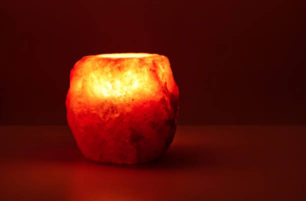 Natural salt stone lamp isolated on red warm background stock photo