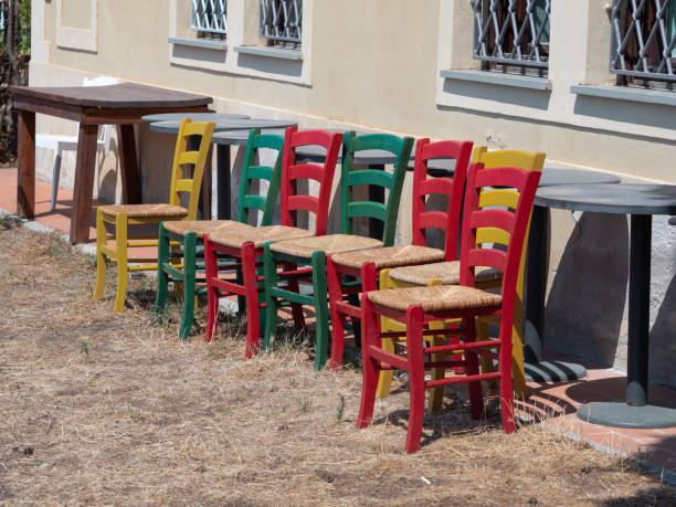 istock Group of Wooden and Colored Chairs side by side Outdoors and Stuffed 1351839017