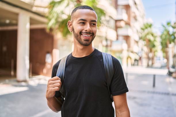 istock Young african american man smiling confident wearing backpack at street 1351843661