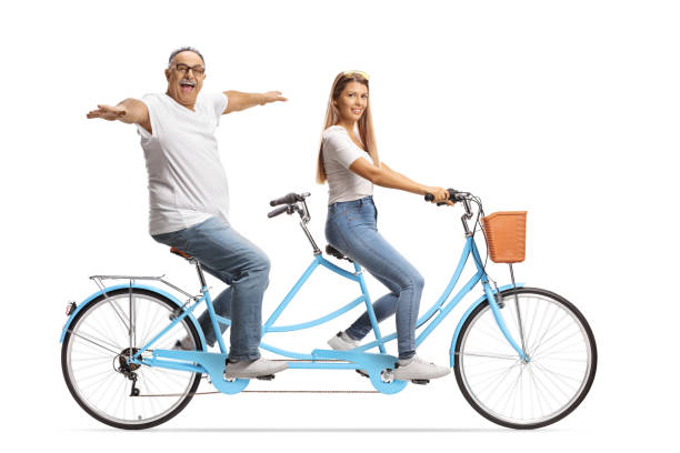 istock Mature man and a young female on a tandem bicycle 1351843884