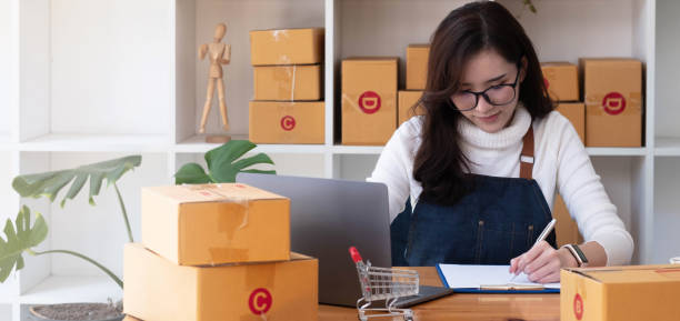 istock Young start up small business owner writing address on cardboard box at workplace.small business entrepreneur SME , working with box at home, Online selling, e-commerce, packing concept 1351844048