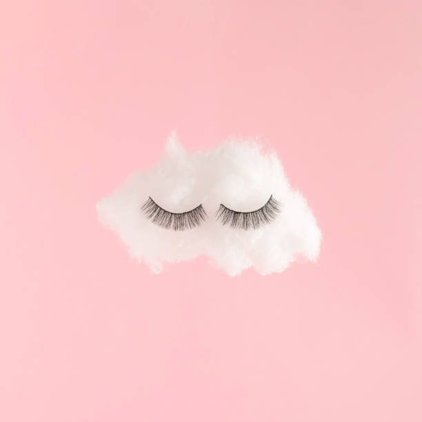 istock White cloud with eyelashes on pink background. Creative minimal dreaming concept. 1351849190