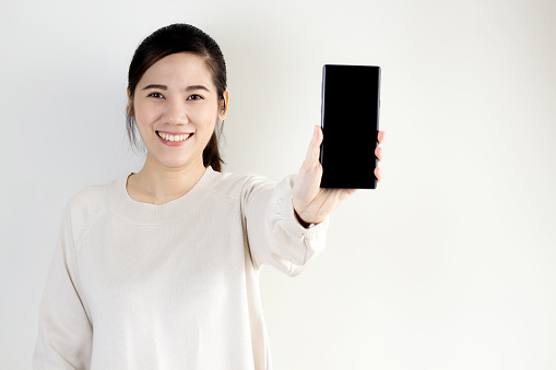 Portrait happy and smiling of Asian woman  hold smartphone and show for promotion and advertising and present the text. Shopping online.