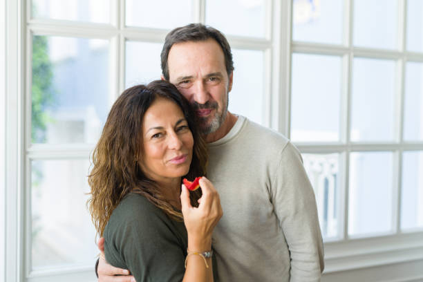 自宅で新鮮なイチゴを食べる中年の先輩夫婦 - senior couple ストックフォトと画像