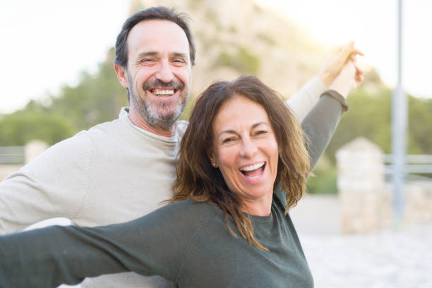 pareja romántica sonriendo y bailando en un día soleado - 50 59 años fotografías e imágenes de stock