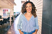 istock Middle age hispanic woman smiling happy walking at the city. 1351854078