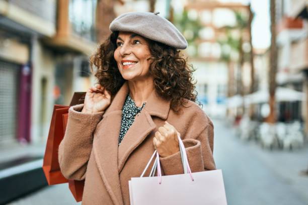 도시에서 행복한 쇼핑을 웃고 있는 중년 히스패닉 여성. - shopping women bag old 뉴스 사진 이미지