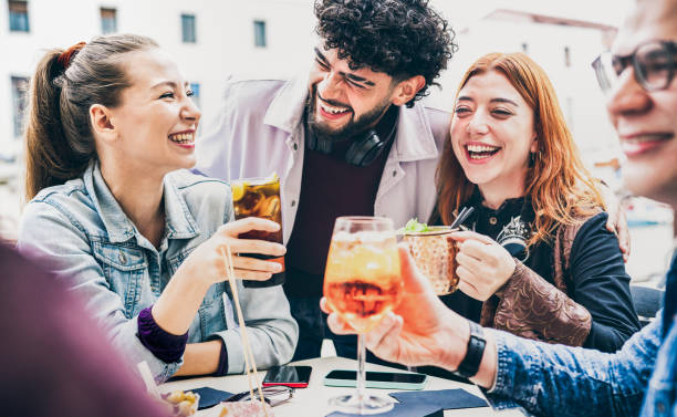 istock People having fun drinking at open air bar on happy hour - Life style concept with young friends spending time together talking and sharing cocktails at city sidewalk place - Flat vintage filter 1351855094