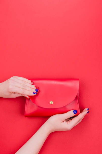 istock Women hands with bright manicure holding red clutch 1351856959