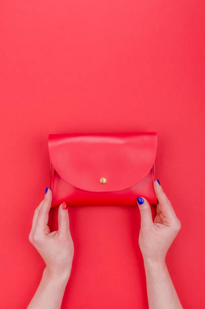 istock Women hands with bright manicure holding red clutch 1351856969