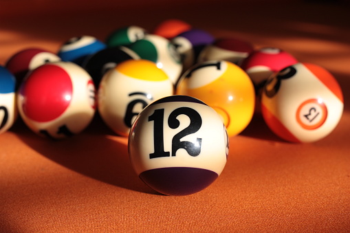 Pool ball number 12 close-up on a blurred background pyramid of billiard balls, Italy