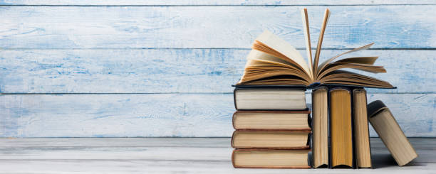 istock Open book, hardback books on wooden table. Back to school. Copy space. 1351857223