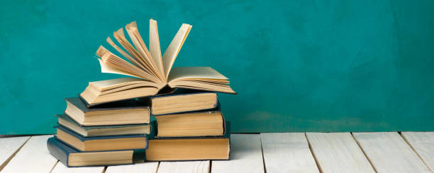 istock Open book, hardback books on wooden table. Back to school. Copy space. 1351858009