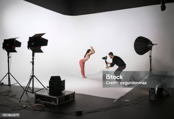 Woman Practicing Yoga While Professional Photographer Shooting In Photo Studio Stock Photo - Download Image Now