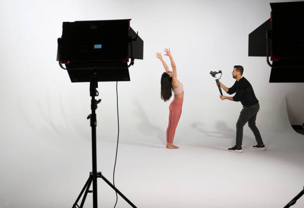 istock Woman practicing yoga, while professional photographer shooting in photo studio 1351862926