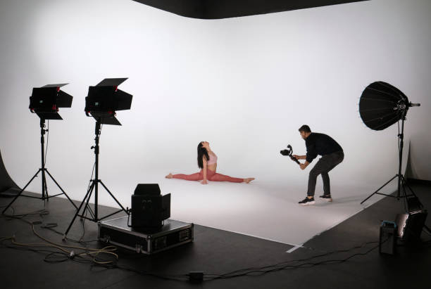 istock Woman practicing yoga, while professional photographer shooting in photo studio 1351862934