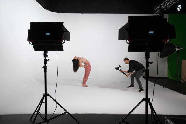 istock Woman practicing yoga, while professional photographer shooting in photo studio 1351862951