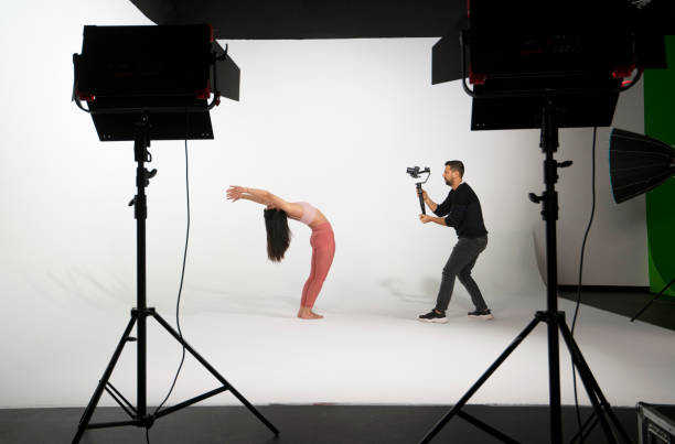 istock Woman practicing yoga, while professional photographer shooting in photo studio 1351863001