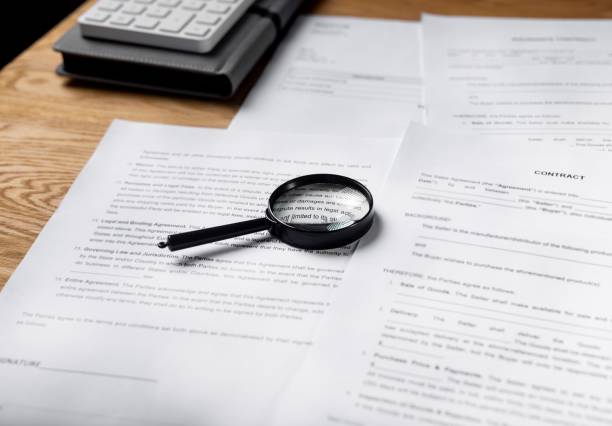 istock Paper contract and business documents on office desk with magnifying glass 1351864288