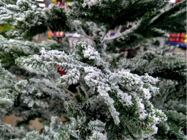 the branch of an artificial christmas tree with artificial snow, close up - fake snow imagens e fotografias de stock