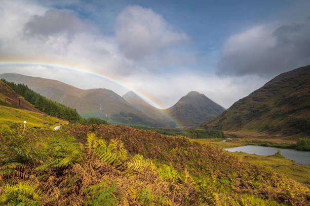 Etive Rainbow An autumnal 3 shot HDR image of a Rainbow in Glen Etive with Bauchaille etive Mor and Buachaille Etive Beag behind, Scotland. buachaille etive beag photos stock pictures, royalty-free photos & images