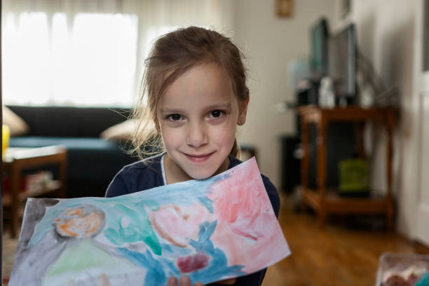 istock Child holding her drawing on a paper 1351868549