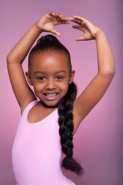 Photo of Cute little African American girl dancing