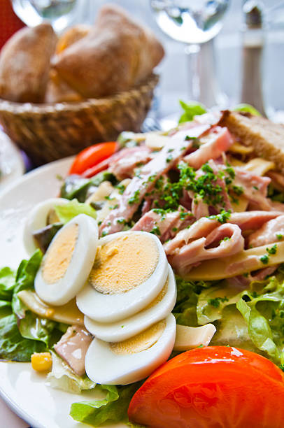 Ham rolled on salad on white background seen from above