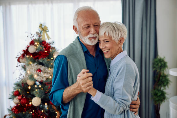 a beautiful mature couple dancing at home for Christmas stock photo