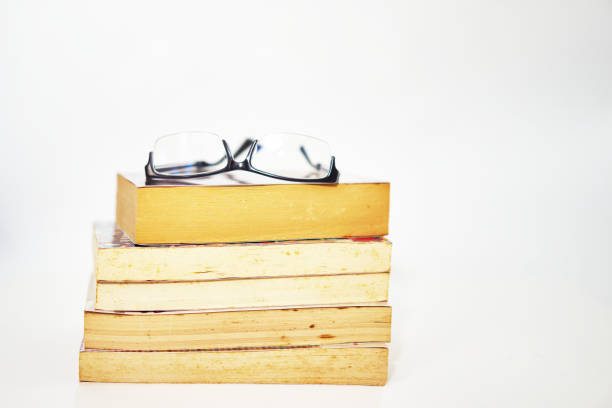 istock stack of books arranged pile on white background with glasses on top 1351875268
