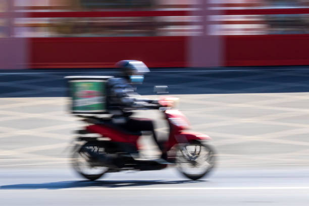 istock Delivery man on motorbike in motion 1351878519