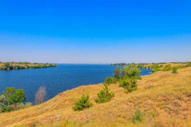 istock Summer landscape with beautiful river, green trees and blue sky 1351880075