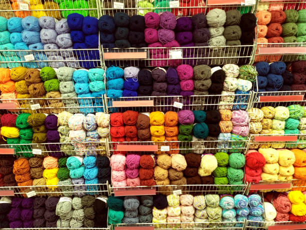 istock Knitted pattern of multi-colored wool yarn on the shop window. Background for knitting. Knitting yarn for handmade winter clothes. Colorful background with a ball of yarn. 1351882925
