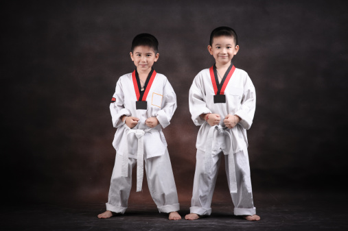 Confidence athlete strong young man wear uniform taekwondo with black belt showing thumbs up while standing over isolated white background. Activity power tradition concept.